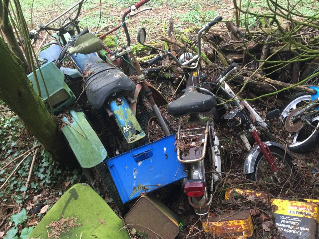 Photo de vieux véhicules abandonnés sur un terrain à l'extérieur de la maison.